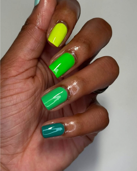 Multishade green nails with the lightest green  on the top section and the darkest  on the bottom of the nail stack.